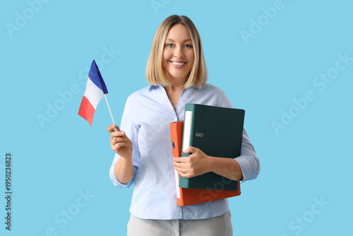 Female French language teacher with flag and folders on blue background