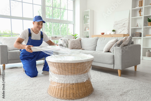 Male worker wrapping rattan...