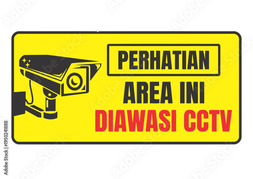 Yellow rectangular warning sign with a black CCTV camera icon and Indonesian text 'PERHATIAN AREA INI DIAWASI CCTV' indicating the area is monitored by CCTV.