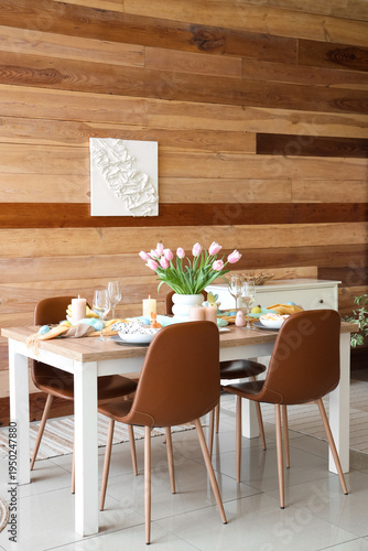 Interior of festive decorated dining room with Easter table setting and chairs