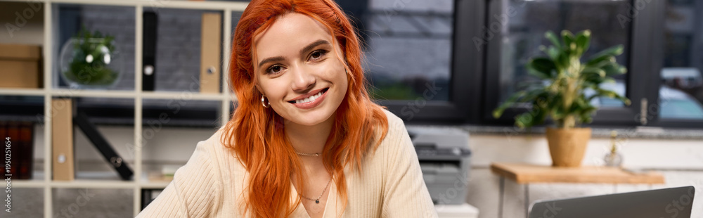 Naklejka premium Bright and cheerful young woman with red hair in a modern office setting