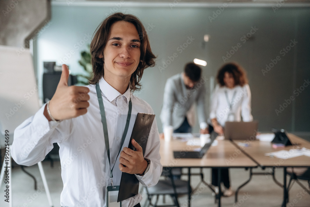 Fototapeta premium Thumb up hand gesture. Group of people are working in the office together as a team