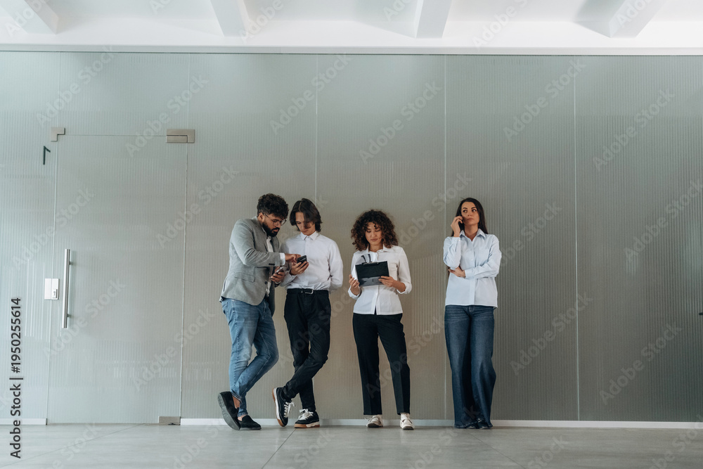 Fototapeta premium Front view of four office workers that are standing indoors and waiting