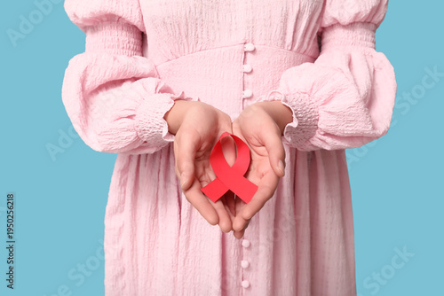 Woman holding red ribbon on...