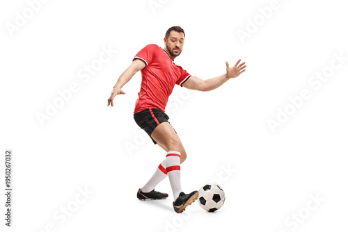Football player in a red jersey top leading a ball