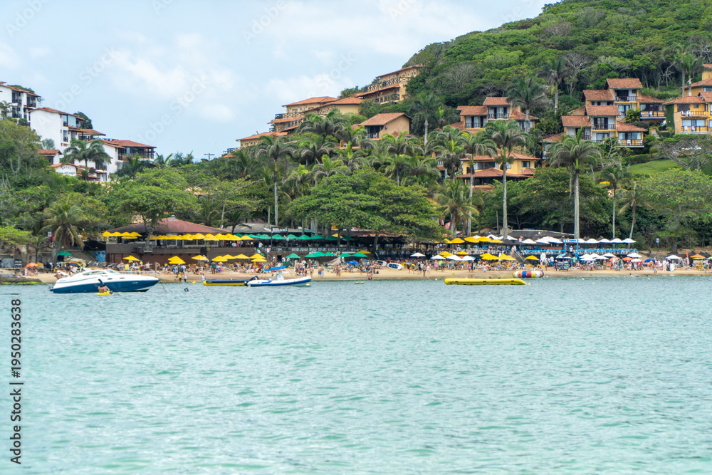 Fototapeta premium View of João Fernandes beach from João Fernandinho with boats and tropical houses over greenery in Búzios Rio de Janeiro Brazil – coastal tourism and seaside lifestyle