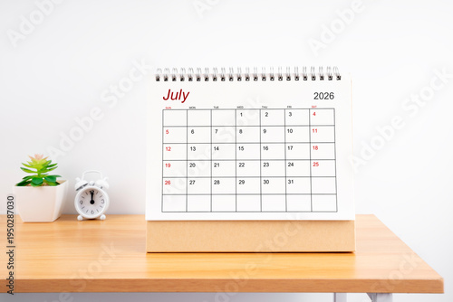 July 2026, Monthly desk calendar for 2026 year on wooden table.