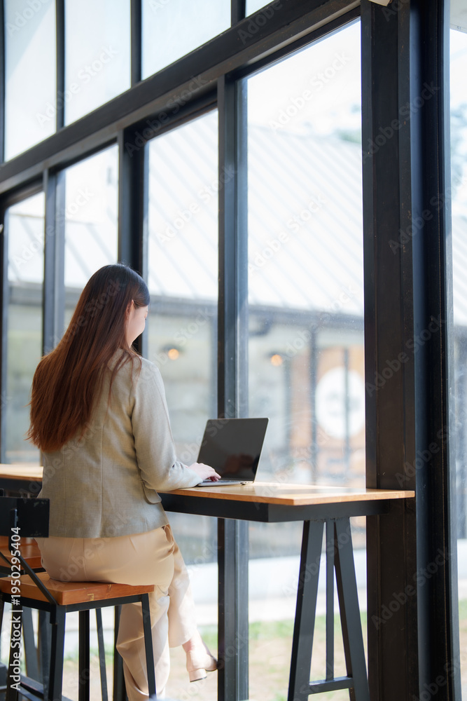 Fototapeta premium Woman working on laptop in modern cafe