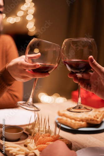 Close-up of couple clinking glasses of wine in restaurant during romantic dinner