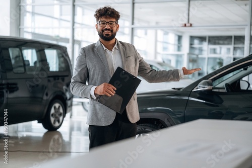 Wallpaper Mural Confident car salesman using digital tablet inside modern showroom Torontodigital.ca