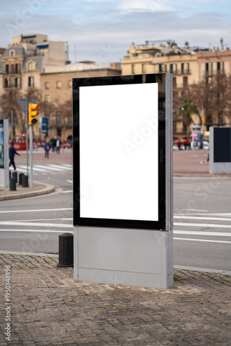Blank vertical digital screen display standing on a city street corner, offering ample advertising space for marketing campaigns and public information in an urban environment