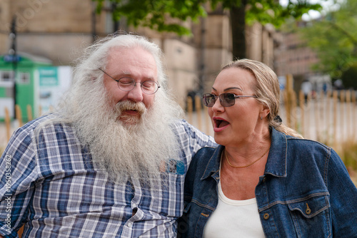 Couple enjoying a conversation outdoors in a city park on a sunny day