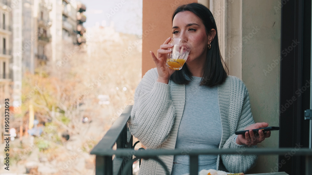 Fototapeta premium Woman On Balcony Drinking Orange Juice Outdoors