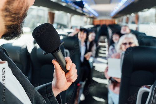Group listening to a speaker on a bus during a trip to a city