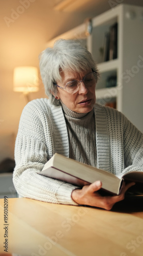 Older Woman Reading Book At Home In Cozy Scene