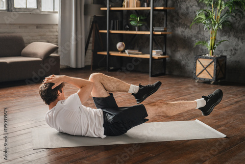 Caucasian man performs core exercise, boat pose or bicycle crunch, training abdominal muscles on mat in living room, strengthening abs muscles, improve balance, enhancing stability, and endurance