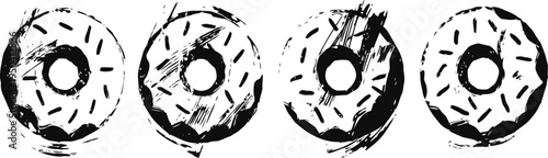 Four black and white donuts with icing and sprinkles in a row