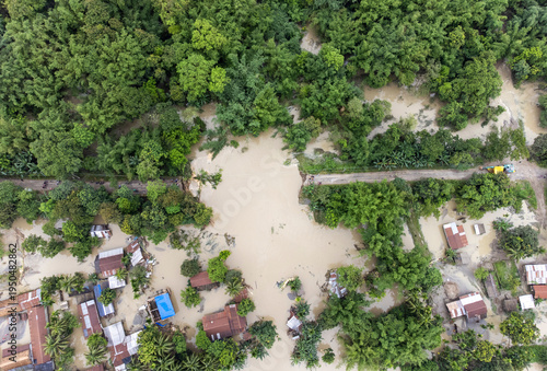 An aerial view shows floodwaters inundating homes, roads, and surrounding vegetation after heavy rainfall
