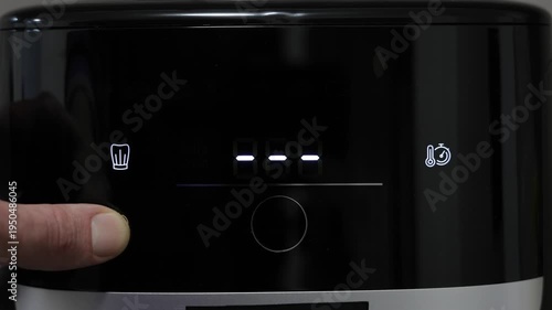 Human finger pressing start button on digital air fryer panel. Digital air fryer interface display. Menu and settings before start cooking.