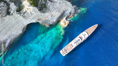 Aerial drone top down photo of luxury yacht anchored in paradise island bay with turquoise crystal clear sea