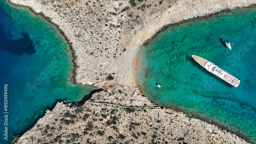 Aerial drone top down photo of luxury yacht anchored in paradise island bay with turquoise crystal clear sea