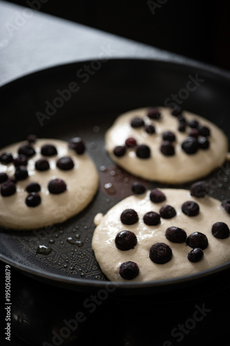 Pancakes mit Blaubeeren in der Pfanne. Pfannkuchen mit Blaubeeren