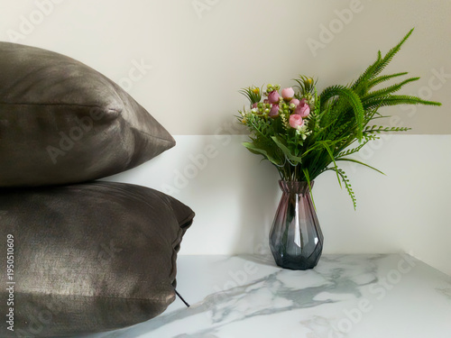 Elegant home decor with pillows and floral arrangement. 
