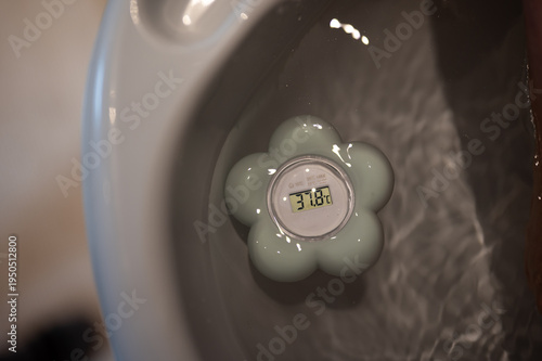 Thermometer im Wasser. Wassertemperatur messen 37,8°.