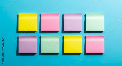 Eight pastel-colored sticky notes in yellow, pink, purple, and mint arranged neatly in two rows of four on a light blue surface, ideal for planning or reminders.