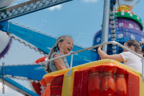 Photos Happy girls having fun on a swing ride at amusement park