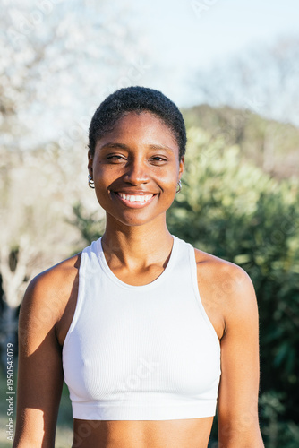 Smiling woman posing outdoors for fitness portrait