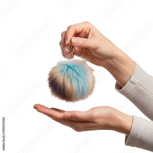 Hands holding a fluffy pompom keychain