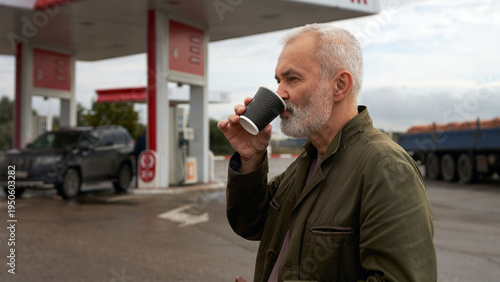 Foto A motorist drinks coffee at a gas station