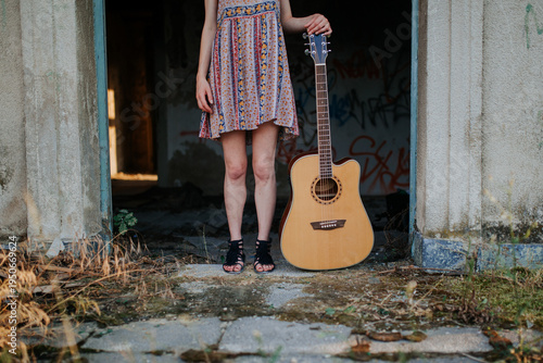 Woman Standing in Doorway with Acoustic Guitar