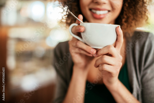 Smiling woman holding hot beverage in cafe