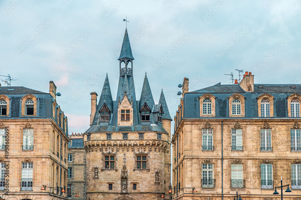 Obraz premium Porte Cailhau historic medieval gate and surrounding classical architecture in Bordeaux city center, Gironde, Nouvelle-Aquitaine, France. French old town buildings. Travel and touristic landmark