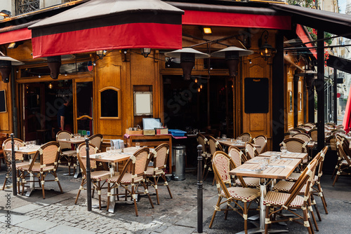 Typical view of the Parisian street with tables with tables of cafe in Paris, France. Architecture and landmark of Paris. Cozy Paris cityscape