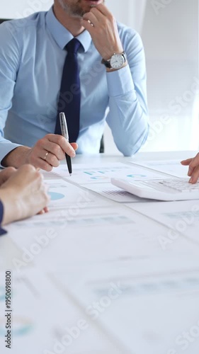 Business professionals analyzing financial charts and graphs during corporate meeting in modern office, focusing on data strategy, growth performance, and market planning