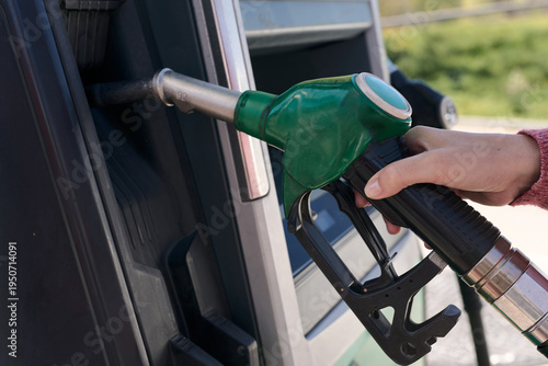 Quadro su tela Hand holding gas pump nozzle filling up car oil crisis, inflation