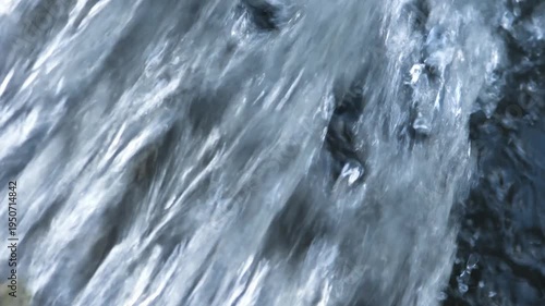Stormwater rushing down small waterfall in urban drainage channel.