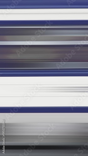 Fast moving white blue passenger train creating horizontal motion blur while passing railway platform.