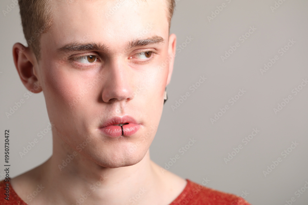 Naklejka premium Young man with piercings on light grey background, closeup. Space for text