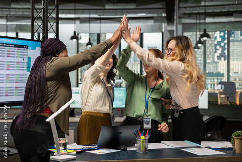 Tableau sur toile Multiethnic colleagues sharing a high five and celebrating their team success, feeling pleased with their victory and achievement in developing the company activity
