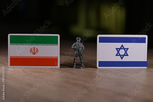 A tin soldier on the background of the flags of Iran and Israel.