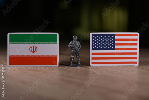 A tin soldier on the background of the flags of the United States and Iran.