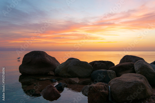 Foto Serene Sunset Over Ocean with Boulders and Colorful Sky In Dahab