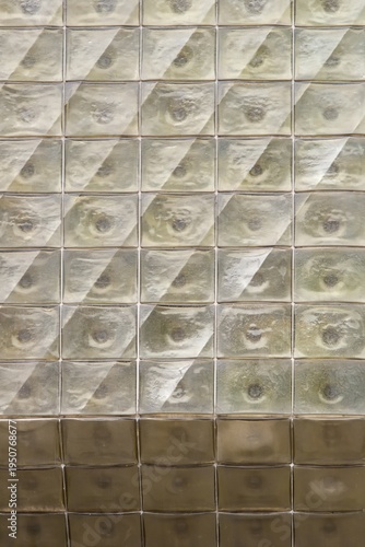 Abstract geometric pattern of textured glass blocks with bubble reflections