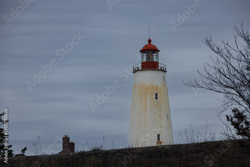 Sandy Hook Lighthouse with Red Lantern Dome Against Overcast Winter Sky New Jersey