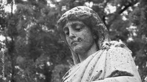 Grieving cemetery statue. Portrait, with detail of face. Black & white. HD video.