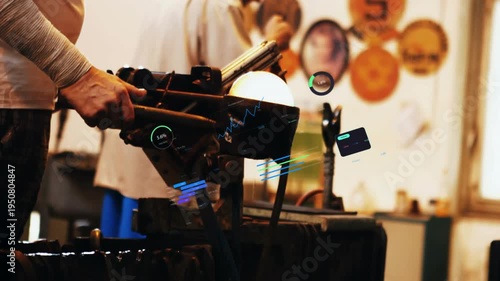 Glassblower rotating blowpipe reheating molten glass while helper handing tools shaping vessel